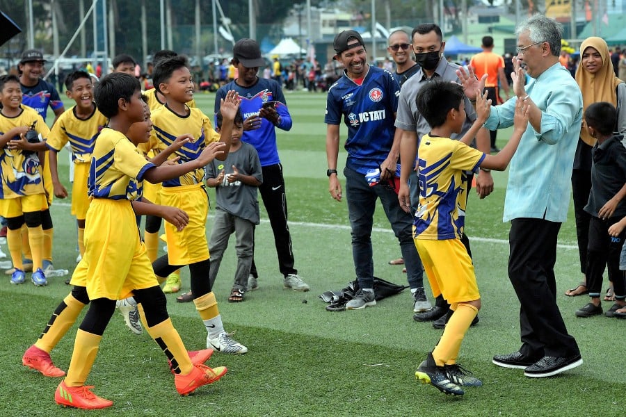 Yang di-Pertuan Agong Al-Sultan Abdullah Ri’ayatuddin Al-Mustafa Billah Shah with a group of young players during the Under 12 Grassroots Football Tournament in Kuantan, Pahang. BERNAMA FILE PIC