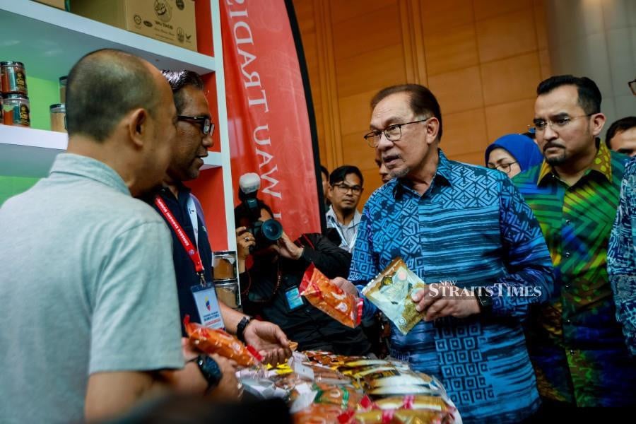Prime Minister Datuk Seri Anwar Ibrahim at one of the booths at the Bumiputera Economic Congress at Putrajaya International Convention Centre. With him is Majlis Amanah Rakyat chairman Datuk Dr Asyraf Wajdi Dusuki (right). NSTP/ASYRAF HAMZAH