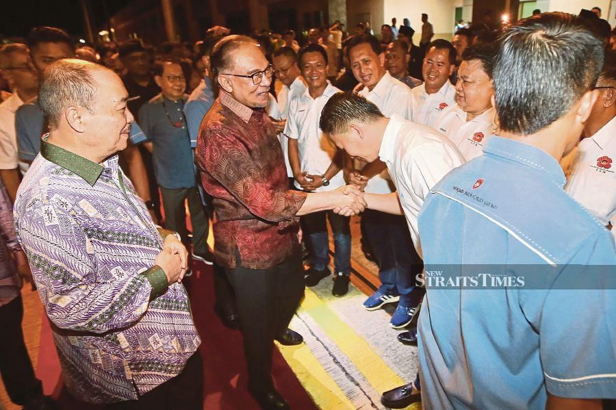 Prime Minister Datuk Seri Anwar Ibrahim shakes hand with the president of Pertubuhan Kadazan Dusun Murut (KDM) Datuk Peter Antony, while Sabah chief minister Datuk Seri Hajiji Noor looks on. - NSTP/MOHD ADAM ARININ