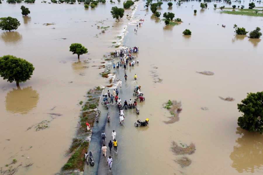 People walk through floodwaters after heavy rainfall in Hadeja, Nigeria, Sept 19, 2022. - AP Pic
