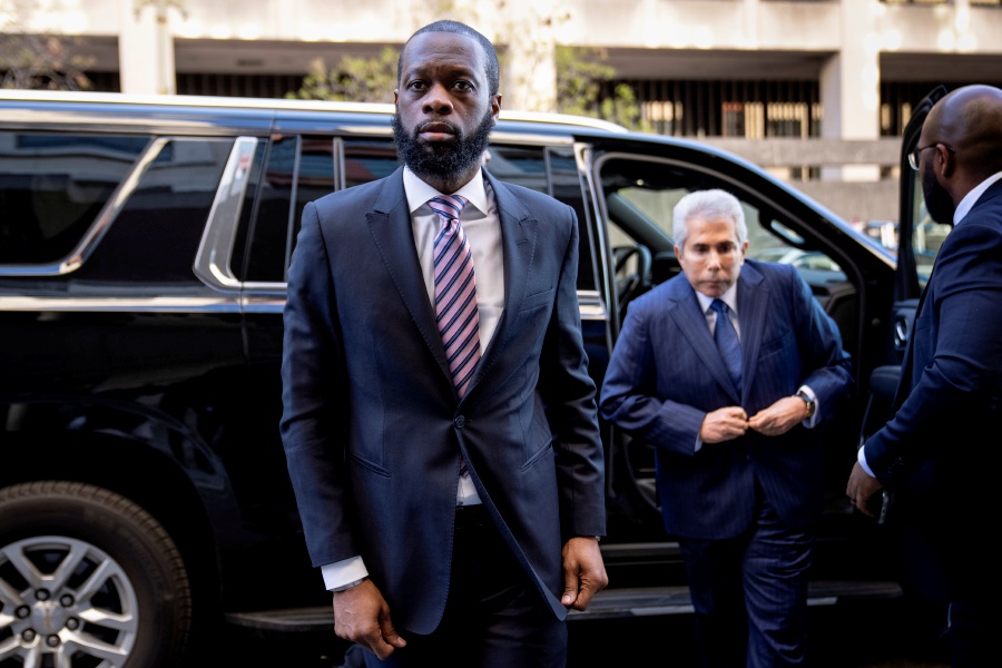 Prakazrel “Pras” Michel, center, a member of the 1990s hip-hop group the Fugees, accompanied by defense lawyer David Kenner, right, arrives at federal court for his trial in an alleged campaign finance conspiracy, Thursday, March 30, 2023, in Washington.- AP Pic