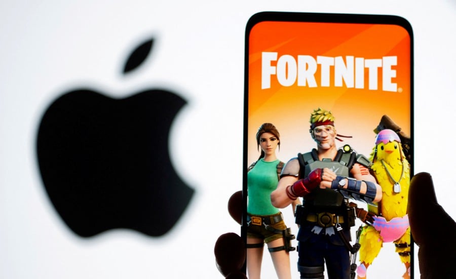 Fortnite game graphic is displayed on a smartphone in front of Apple logo in this illustration taken May 2, 2021. REUTERS/Dado Ruvic
