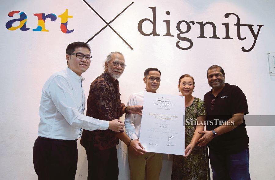 NPC president Datuk Ahirudin Attan (2nd from left) presenting the Muhibbah Award to chief executive officer of Dignity for Children Foundation, Petrina Shee Shiang Fei (2nd from right), while MACROKIOSK chief executive officer Datuk Kenny Goh (centre), MACROKIOSK chief operating officer Datuk Henry Goh (left) and co-founder of Dignity for Children Foundation, Reverend Elisha Satvinder look on. - NSTP/HAIRUL ANUAR RAHIM