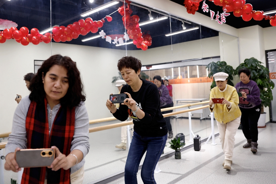 Women attend a smartphone photography class at Mama Sunset, a learning centre for middle-aged and senior people in Beijing, China. (REUTERS/Tingshu Wang)