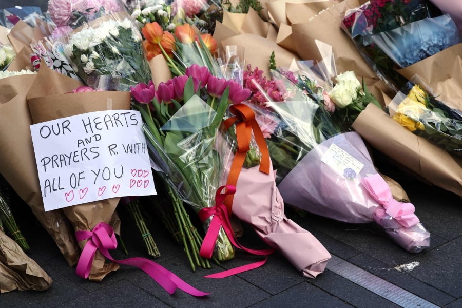 Messages accompany flowers left outside the Westfield Bondi Junction shopping mall, the day after a 40-year-old knifeman with mental illness roamed the packed shopping centre killing six people and seriously wounding a dozen others. (Photo by DAVID GRAY / AFP)