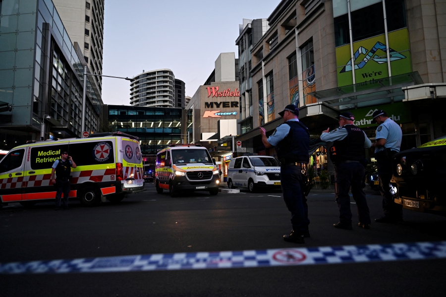 Emergency service workers stand near Bondi Junction after multiple people were stabbed inside the Westfield Bondi Junction shopping centre in Sydney, April 13, 2024. - AAP Image/Steven Saphore via REUTERS