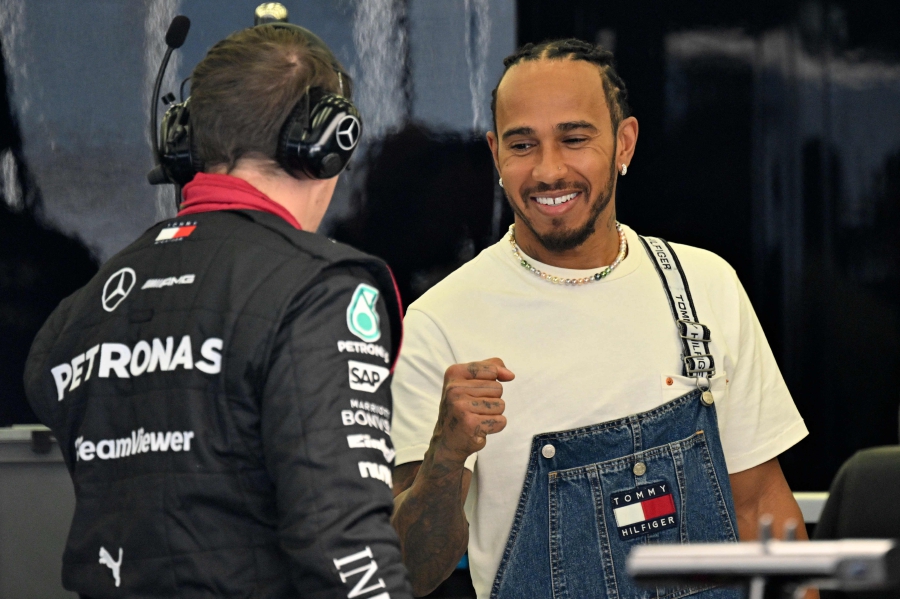 Mercedes' British driver Lewis Hamilton (right) gestures to his team member in the garage ahead of the first practice session of the Bahrain Formula One Grand Prix at the Bahrain International Circuit in Sakhir. (Photo by ANDREJ ISAKOVIC / AFP)