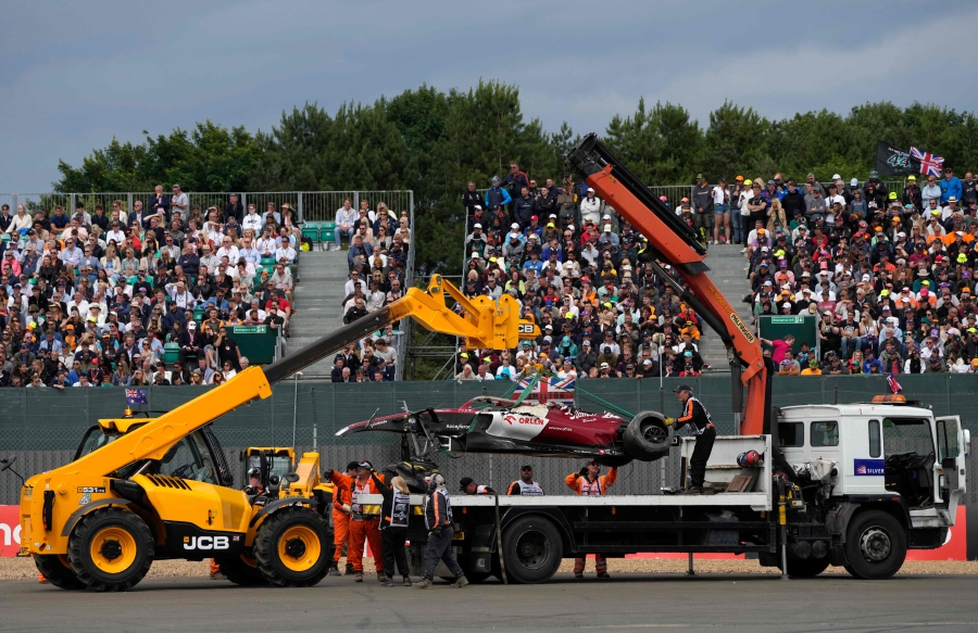 The damaged car of Alfa Romeo's Chinese driver Zhou Guanyu is taken away after crashing at the start during the Formula One British Grand Prix at the Silverstone motor racing circuit in Silverstone, central England on July 3, 2022. (Photo by Matt Dunham / POOL / AFP)