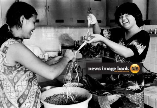 29 May 1979: Housewife Mrs Sakura Koh, 25, (left) and her helper Wong Ai Leen, 16, preparing the traditional "chung" or sticky rice dumplings for the dragon boat festival.