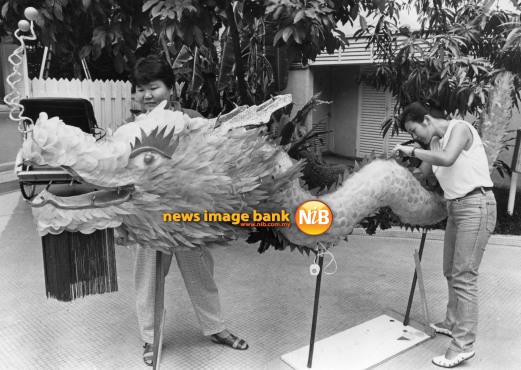26 August 1986: Hotel artists Liew Kim Lian (right) and Agnes Tong putting the final touches to the dragon lantern.