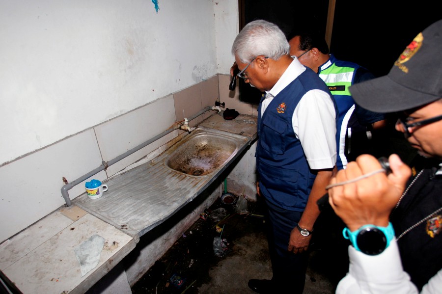 State Human Resources, Health, National Integration, and Indian Community Affairs Committee chairman A. Sivanesan showing a dirty sink during the operation in Ipoh last night. (Bernama Pic)