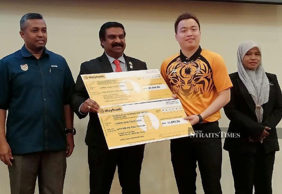 Aaron Chia (second from right) receiving the mock cheques from Melaka state exco member VP Shanmugam in Ayer Keroh today. -NSTP/ NAZRI ABU BAKAR