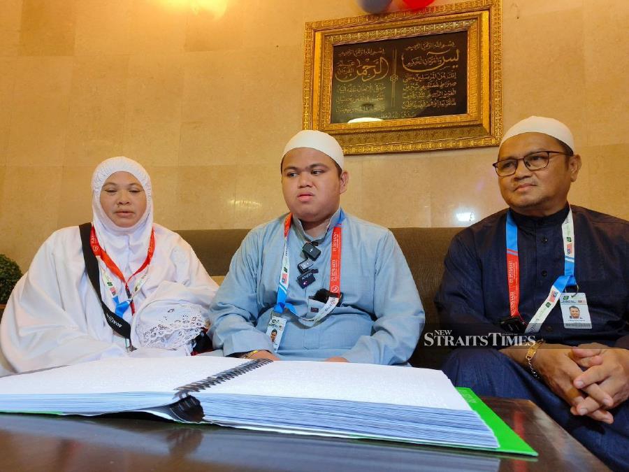  Qayyim (centre) flanked by his parents during an interview at his accommodation in Makkah,