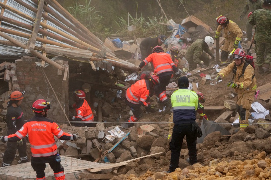 Rescue workers inspect a home destroyed by a deadly landslide that buried dozens of homes in Alausi, Ecuador.--AP PIC