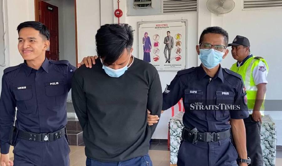 Mohammad Sah Taswat (centre) is escorted by police officers at the Batu Pahat magistrate’s court after his hearing. - NSTP/Alias Abd Rani