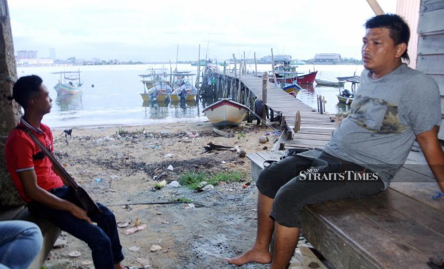 Fishermen Alwi Azmi (right) and Ahmad Muharram Embong welcome the RM250 monthly allowance. - NSTP/Imran Makhzan.