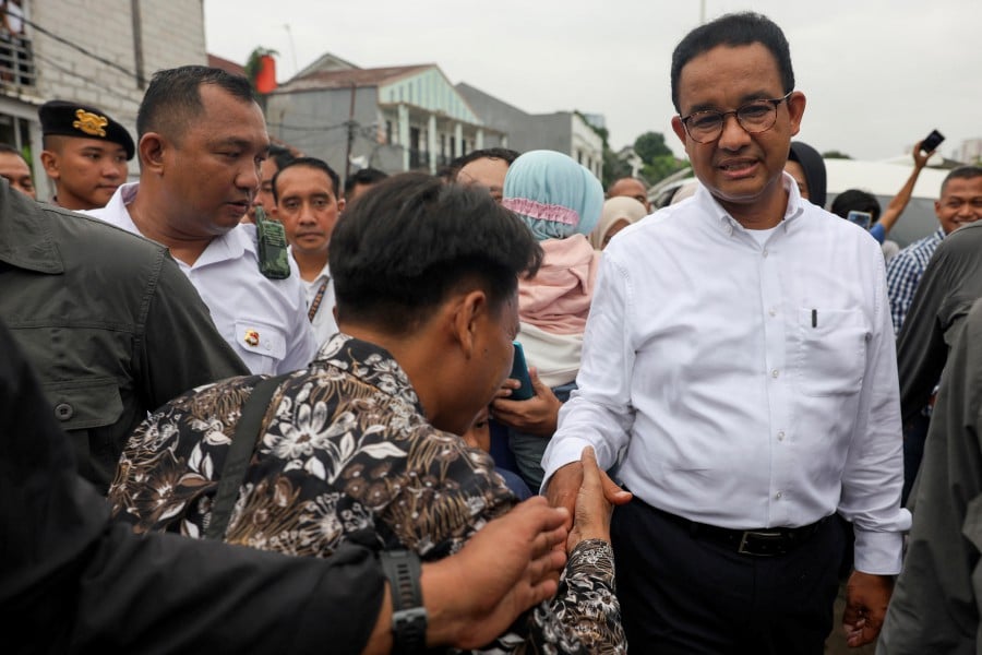 Presidential candidate Anies Baswedan shakes hands with a person on the day of the general election in Jakarta, Indonesia. - REUTERS PIC