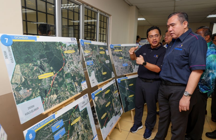 Transport Minister Anthony Loke (right) looks at the route map of the ECRL project during the ECRL Career Carnival Program at Dewan Datuk Abdul Hamid, Batang Kali today."- Bernama pic