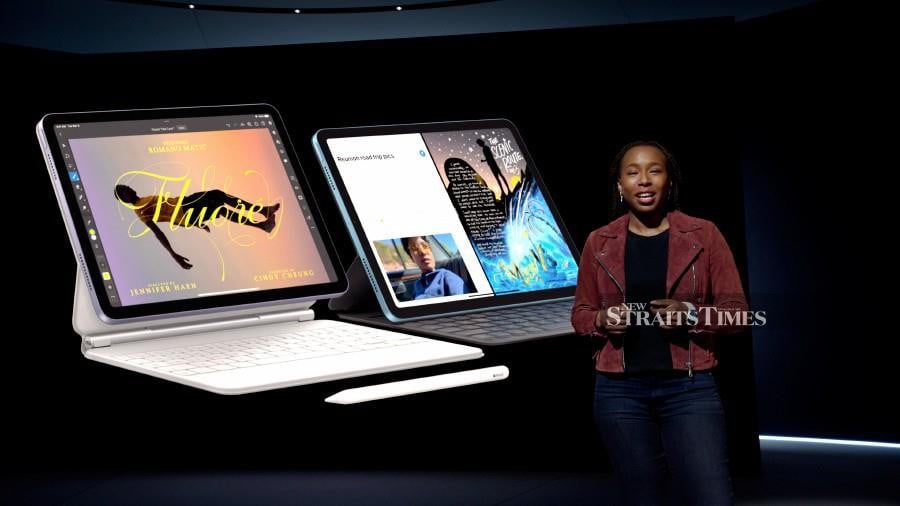 Apple’s Angellina Kyazike showcases the new iPad Air along with Magic Keyboard and Apple Pencil during a special event at Apple Park.