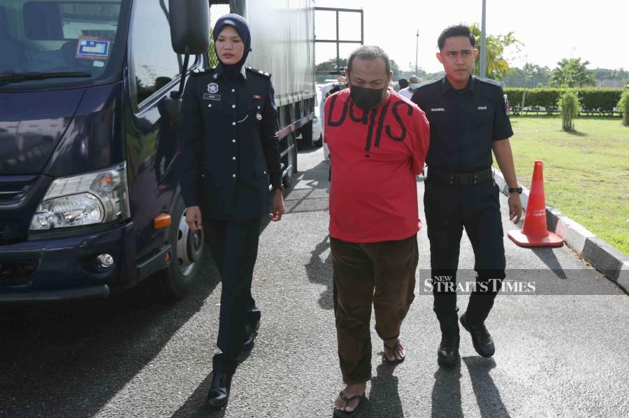Mohd Aseri Musa (centre) is escorted by police officers at the Alor Star Courts Complex ahead of the trial. - NSTP/SYAHARIM ABIDIN