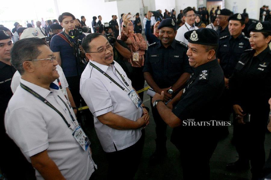 Deputy Inspector General of Police, Datuk Seri Ayob Khan Mydin Pitchay (right) share a light moment with Election Commission chairman Tan Sri Abdul Ghani Salleh, during the early voting process at the Selangor police headquarters inShah Alam. -NSTP/FAIZ ANUAR