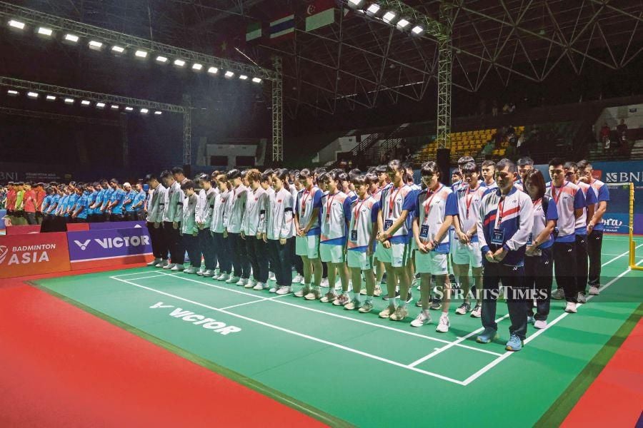 In the handout picture taken and released on July 1, 2024 by public relations and media division of the Indonesian Badminton Association (PBSI) shows, Chinese badminton players and coaches (in white jackets and black armbands), along with all players competing in the Asia Junior Championships, praying together for the late Chinese player Zhang Zhijie, who collapsed during a match against Japan in the preliminary round and received medical assistance in Yogyakarta. AFP PIC 
