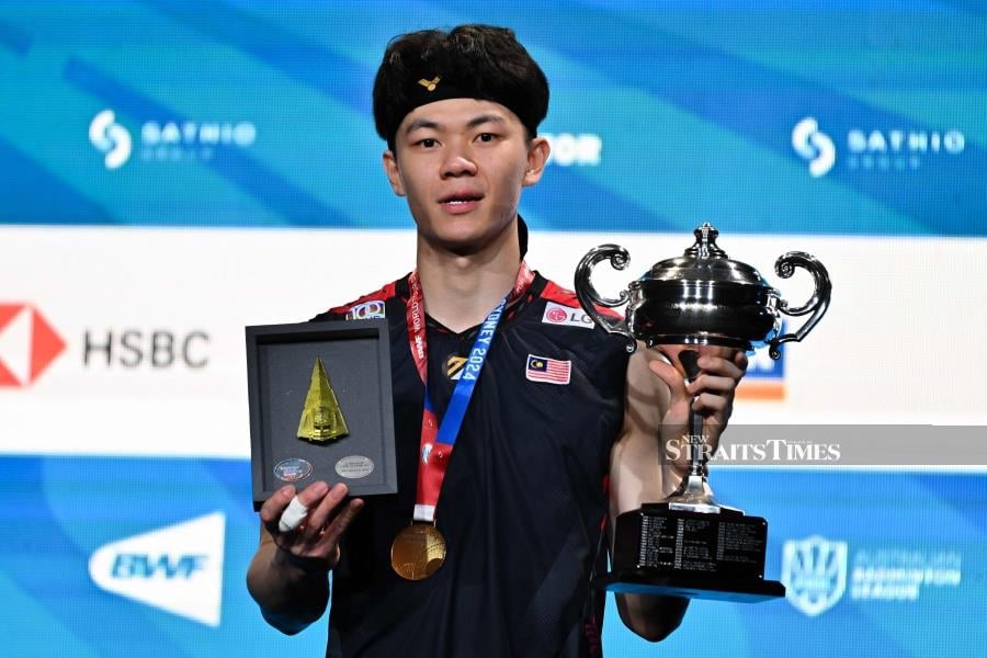 Malaysia's Lee Zii Jia poses on the podium with his trophy following his victory against Japan's Kodai Naraoka during their men's singles final at the Australia Open in Sydney on Sunday. AFP PIC 