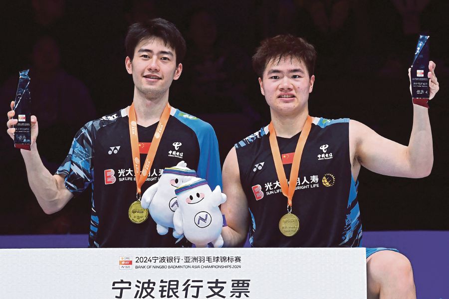 China's Liang Weikeng (right) and Wang Chang pose with their trophies after winning the men's doubles final match against Malaysia's Goh Sze Fei and Nur Izzuddin at the Badminton Asia Championships in Ningbo, in eastern China's Zhejiang province. (Photo by AFP) 
