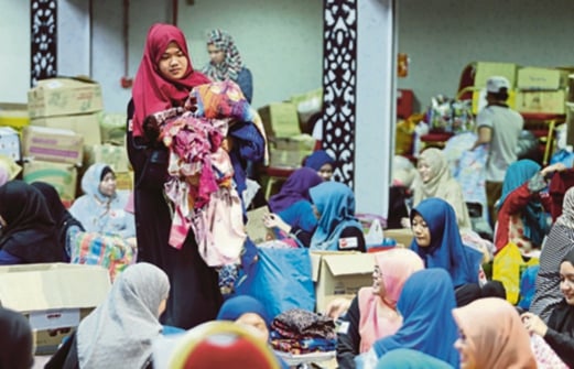 Volunteers of the Baju Raya project helping out at the donation centre. Pix by MOHD KHAIRUL HELMY MOHD DIN.