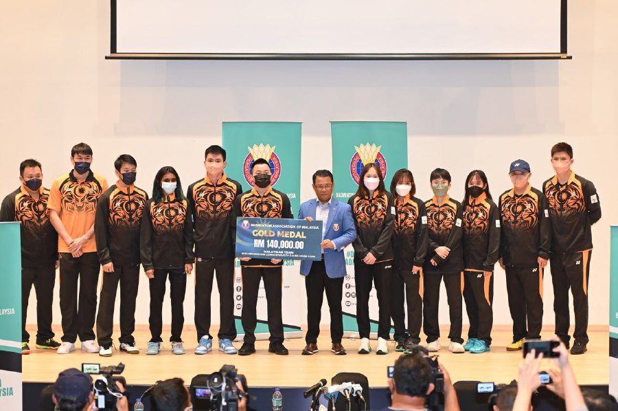 BAM president Tan Sri Norza Zakaria (centre) presents a mock cheque to players and coaches, who contributed and did well at the Hanoi Sea Games and Commonwealth Games at ABM in Bukit Kiara yesterday. PIC COURTESY OF BAM