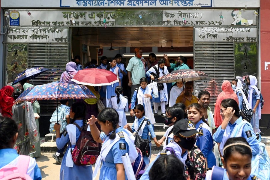 Students leaving their school compound carry umbrellas on a hot summer day in Dhaka, amid the ongoing heatwave. Millions of students returned to their reopened schools across Bangladesh on April 28, despite a lingering heatwave that prompted a nationwide classroom shutdown order last weekend. - AFP pic