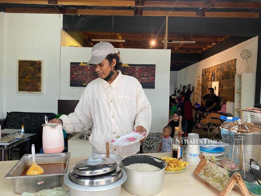 Burhanuddin Bakri preparing a meal for the evacuees in a studio.