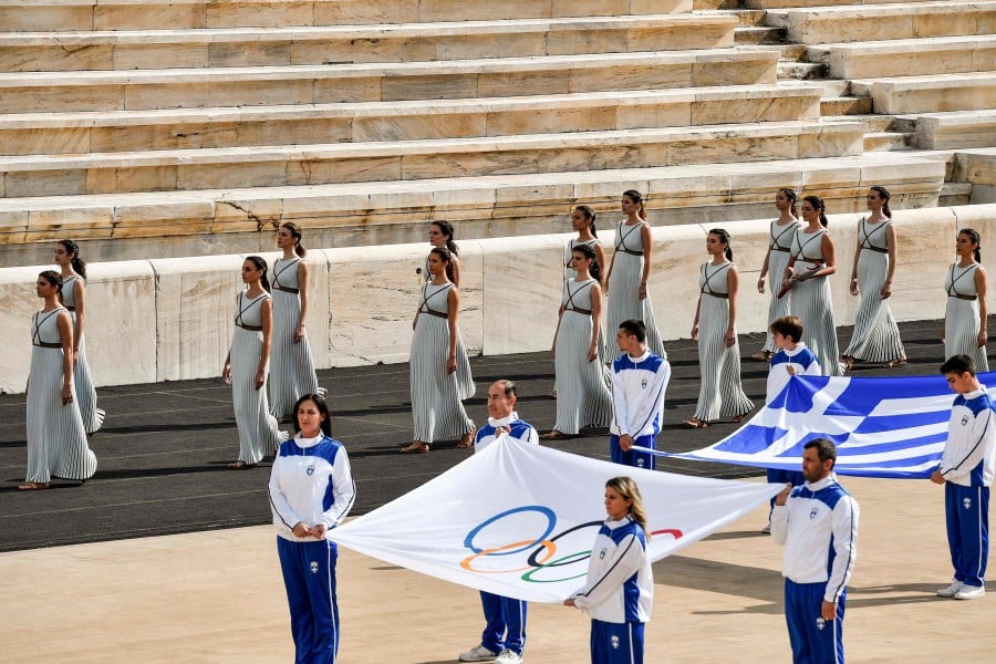 Actresses in the role of priestesses enter the stadium during the handover ceremony of the Olympic Flame for the Beijing 2022 Winter Olympics at Panathinean stadium in Athens, on October 19, 2021. - The flame will be transported by torch relay to Beijing, China, which will host the 2022 Winter Olympics from February 4-20, 2022. - AFP pic