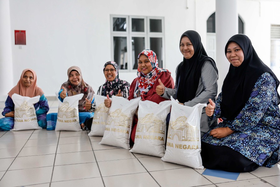 Some of the recipients or the 10kg bag of white rice donated by His Majesty Sultan Ibrahim, King of Malaysia in Kampung Batu Muda today.Bernama pic