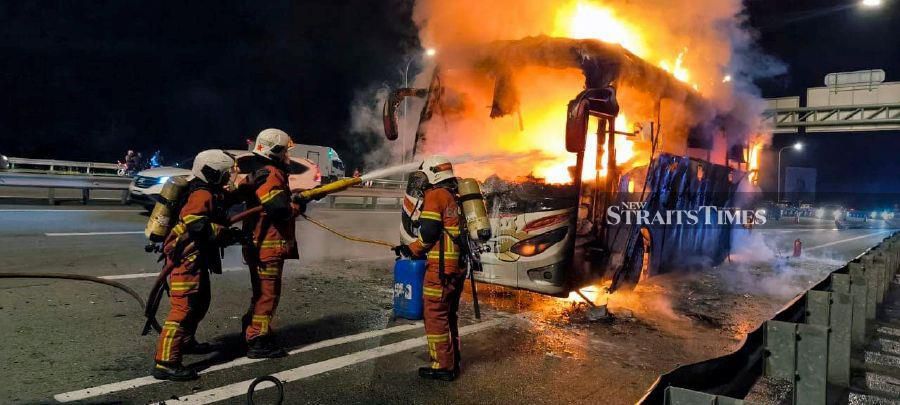 Firemen on the scence after an express buss caught fire at Km 242.3 of the North South Expressway (PLUS) northbound. - Pic courtesy of Fire and Rescue Dept 