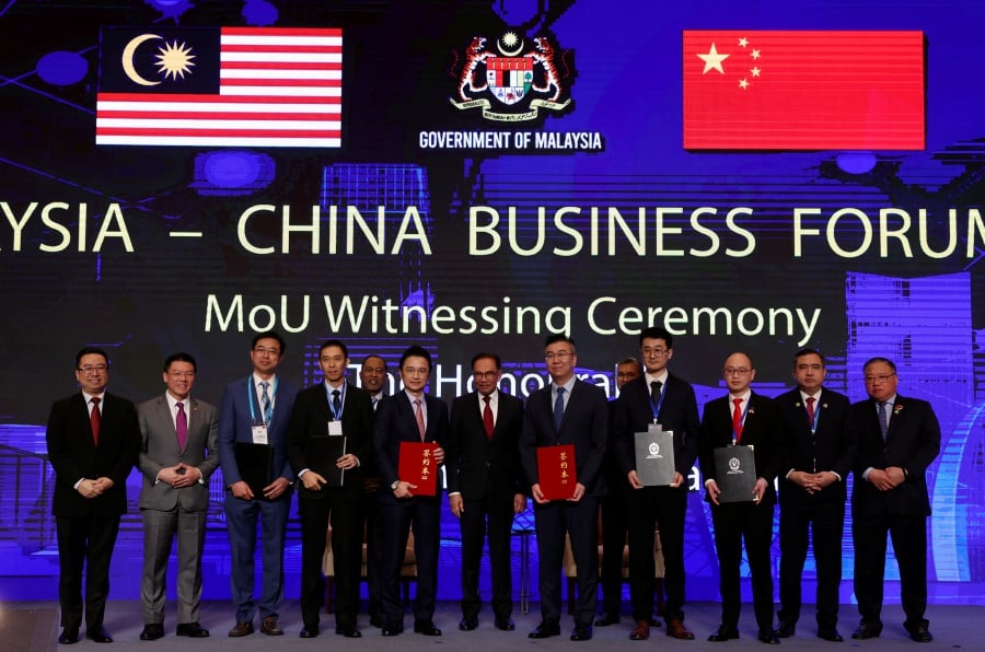 Prime Minister Datuk Seri Anwar Ibrahim (middle) witnessed the exchange of Memorandum of Understanding (MoU) between Paragon Education Sdn Bhd and Illume Research, Sunsuria Berhad & IAT Automobile Technology Co. Ltd and Mutu Nusantara Sdn Bhd and Shanghai DC Science Co. Ltd. during the Malaysia-China Business Forum 2023 today.- BERNAMA Pic