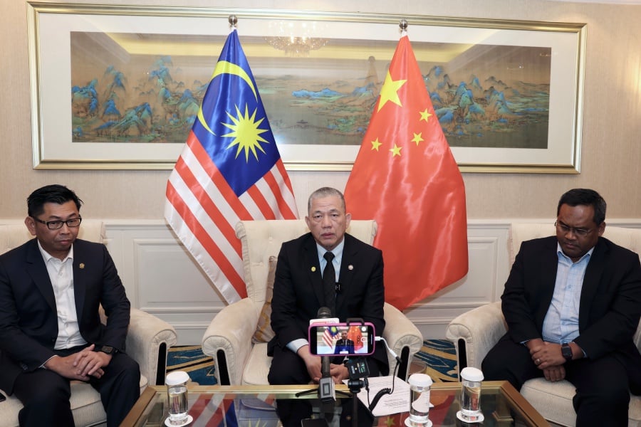 Deputy Prime Minister Datuk Seri Fadillah Yusof (middle) during a press conference after ending the third day of his official visit to Beijing, today.