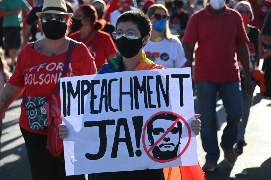 A denmonstrator holds a sign reading “Impeachment now!” during a protest against the government of Brazilian President Jair Bolsonaro at the Esplanede of Ministries in Brasilia, on July 24, 2021. (Photo by EVARISTO SA / AFP)