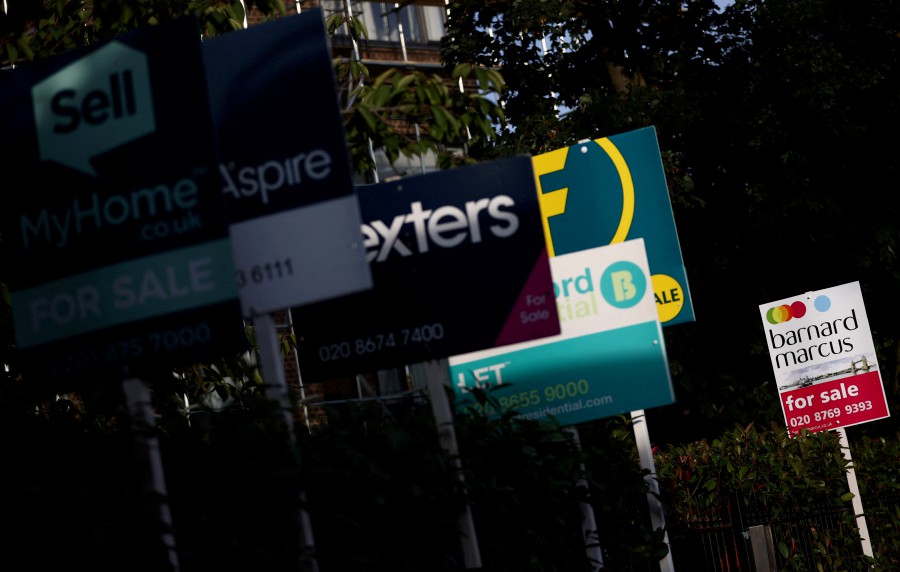 FILE PHOTO: Property estate agent sales and letting signs are seen attached to railings outside an apartment building in south London, Britain, September 23, 2021. REUTERS/Hannah McKay/File Photo