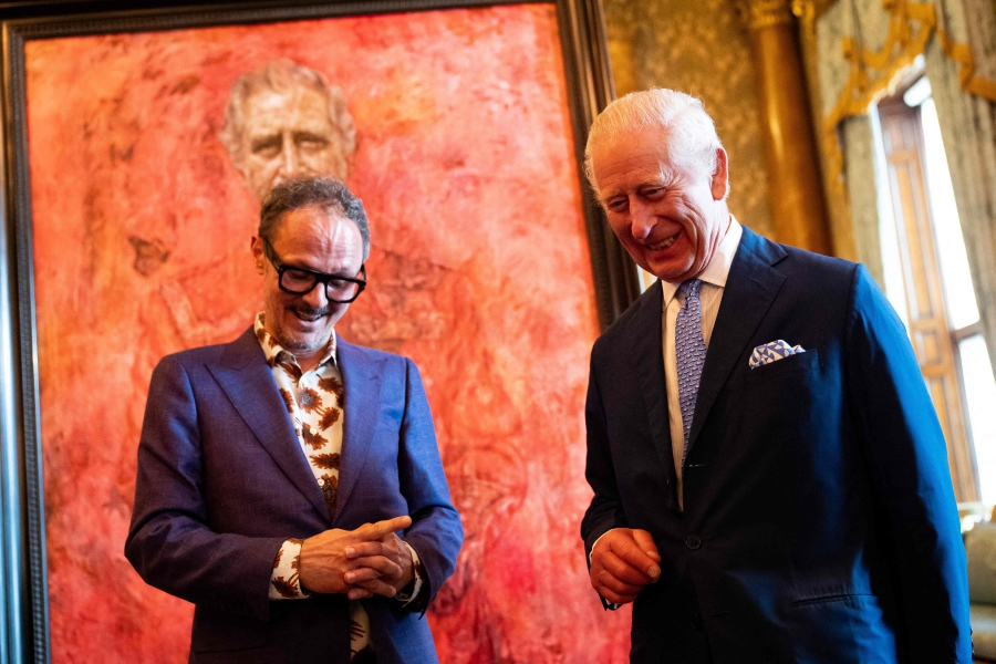 Britain's King Charles III (right) reacts as he stands alongside artist Jonathan Yeo, after unveiling an official portrait of himself wearing the uniform of the Welsh Guards, of which he was made Regimental Colonel in 1975, by artist Yeo, in the Blue Drawing Room at Buckingham Palace in London. (Photo by Aaron Chown / POOL / AFP) 