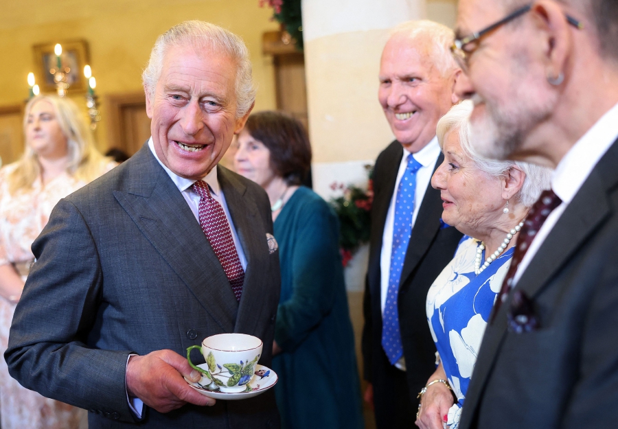 Britain's King Charles III reacts whilst holding a cup and saucer, as he meets with guests during a 75th birthday party for him, hosted by the Prince's Foundation, at Highgrove House in Tetbury, western England. (Photo by Chris Jackson / POOL / AFP)