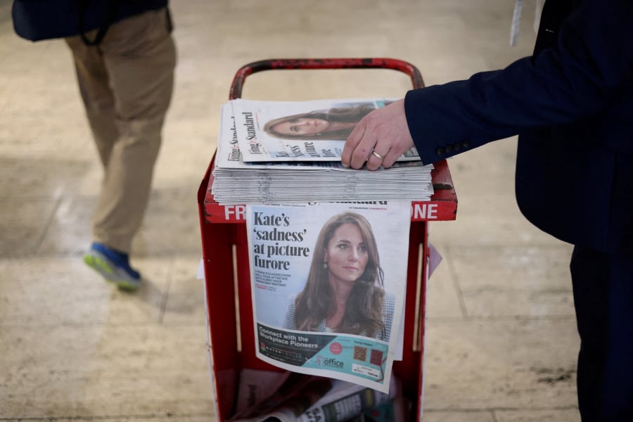 (FILE PHOTO) A commuter picks up a copy of the Evening Standard featuring a picture of Britain's Catherine, Princess of Wales, on the front page at subway station in London, Britain. (REUTERS/Hollie Adams/File Photo)
