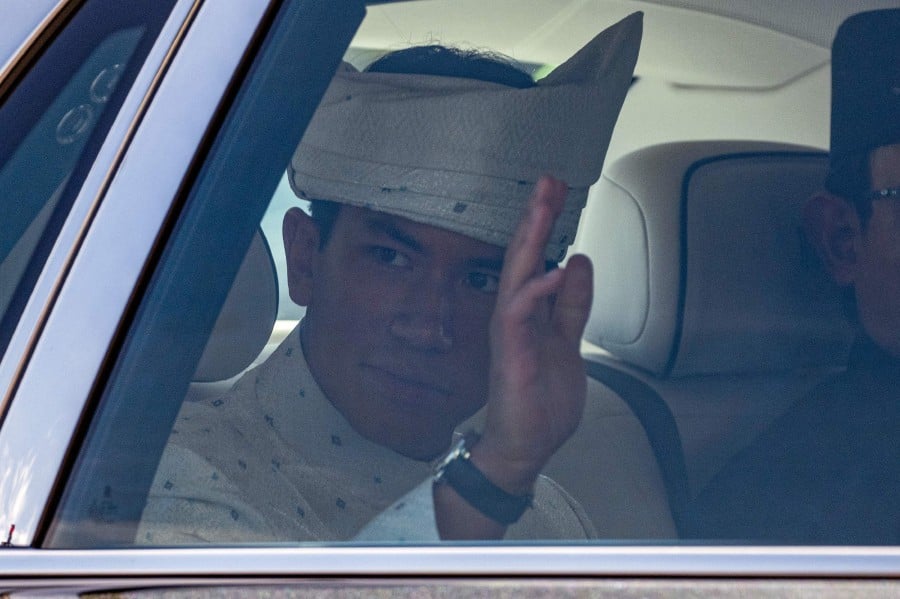 Brunei's Prince Abdul Mateen waves from his car as he leaves following his solemnization as part of the royal wedding at Sultan Omar Ali Saifuddien Mosque in Bandar Seri Begawan in Brunei on January 11, 2024. AFP PIC
