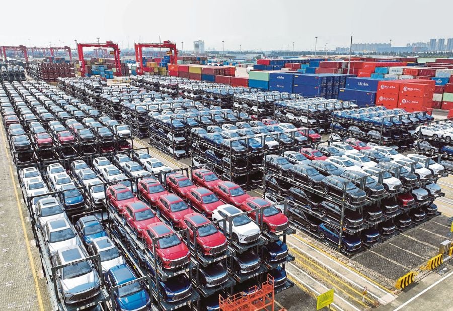 This file photo taken on September 11, 2023 shows BYD electric cars waiting to be loaded on a ship are stacked at the international container terminal of Taicang Port at Suzhou Port, in China's eastern Jiangsu Province. China overtook Japan as the world's biggest vehicle exporter last year, data from the Japan Automobile Manufacturers Association (JAMA) showed on January 31, 2024. (Photo by AFP) / China OUT