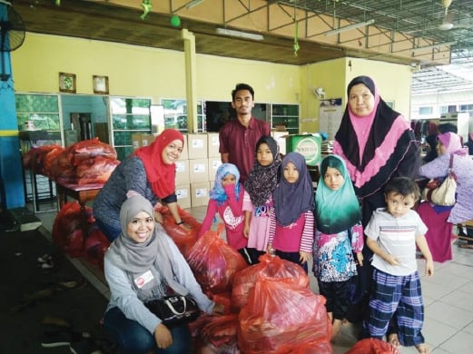 Volunteers with some recipients of the Baju Raya project. 