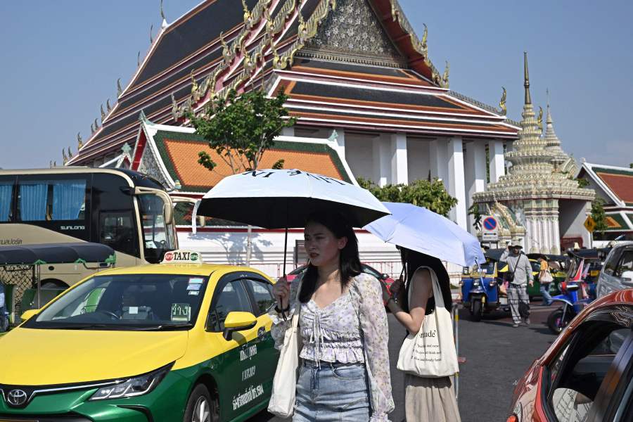 Tourists shield themselves from the sun with umbrellas to combat the heat outside Wat Pho Buddhist temple in Bangkok. Thai authorities issued an extreme heat warning for Bangkok urging people to stay indoors for their own safety as temperatures soared. - AFP pic