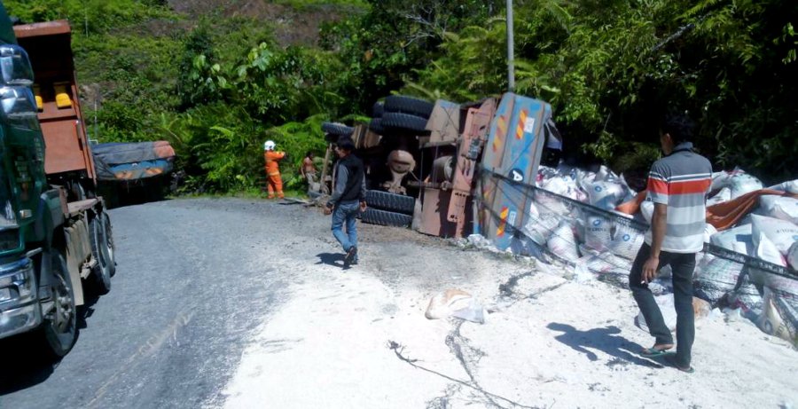 A lorry trailer driver, Ahmad Nongkang @ Mado, 59 was killed when his vehicle overturned at KM 76.9 of Jalan Nangoh/ Paitan here this morning. Pix courtesy of Fire and Rescue Department