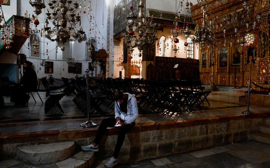  A man uses his mobile phone at the Church of the Nativity in Bethlehem in the Israeli-occupied West Bank on Dec 2, 2023. - Reuters pic