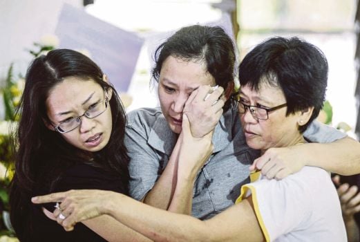  Sun Siew Chin (centre) being comforted by relatives at Choi Hon Ming’s wake in George Town yesterday. Pix by Shahnaz Fazlie Shahrizal/ NSTP