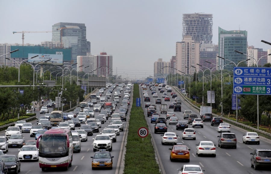 Cars drive on the road during the morning rush hour in Beijing, China. - REUTERS pic